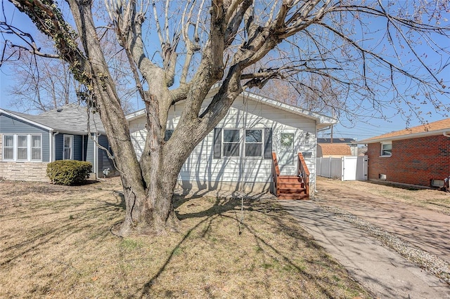 view of front facade with a front lawn and fence