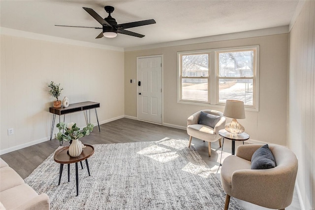 living area with ceiling fan, baseboards, and wood finished floors