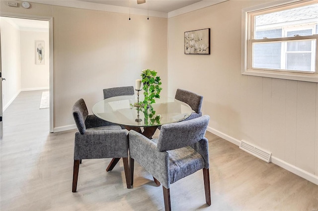 dining room featuring light wood finished floors, visible vents, and baseboards