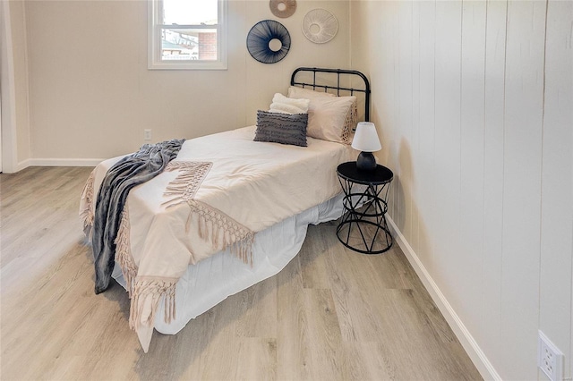 bedroom featuring wood finished floors and baseboards