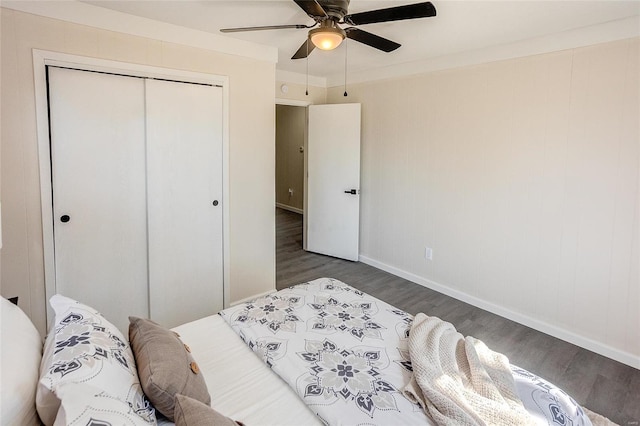 bedroom featuring ceiling fan, wood finished floors, a closet, and baseboards