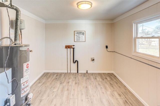 interior space featuring water heater, light wood finished floors, baseboards, hookup for an electric dryer, and laundry area