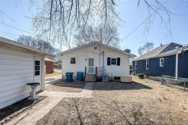 rear view of property with fence and central AC