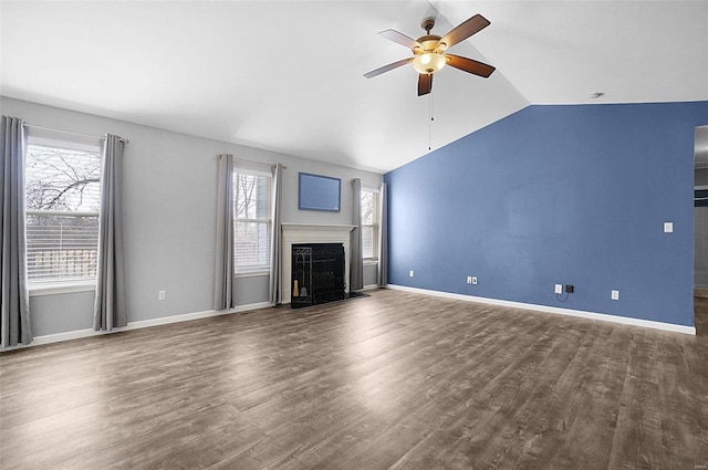 unfurnished living room with wood finished floors, baseboards, a premium fireplace, lofted ceiling, and ceiling fan