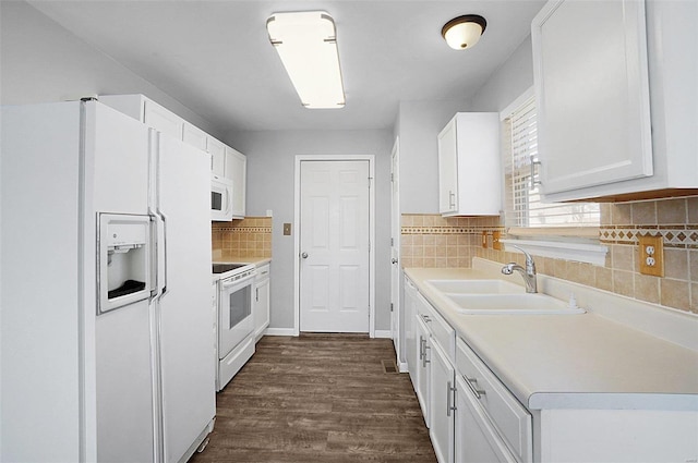 kitchen with white appliances, dark wood finished floors, a sink, light countertops, and white cabinetry