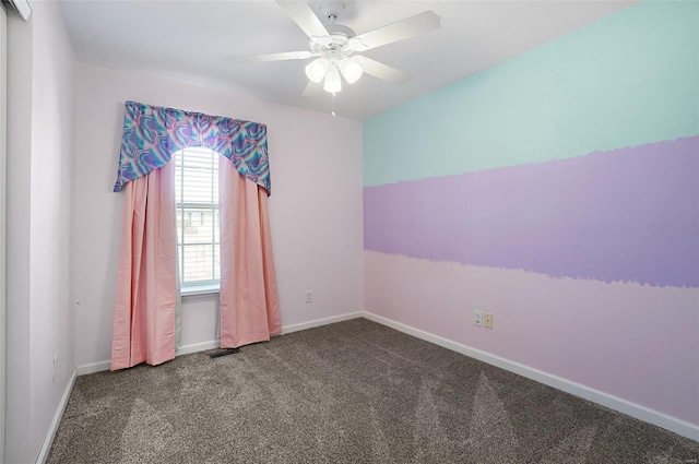 carpeted spare room with visible vents, a ceiling fan, and baseboards