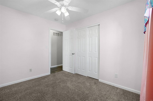 unfurnished bedroom with visible vents, a ceiling fan, dark carpet, a closet, and baseboards