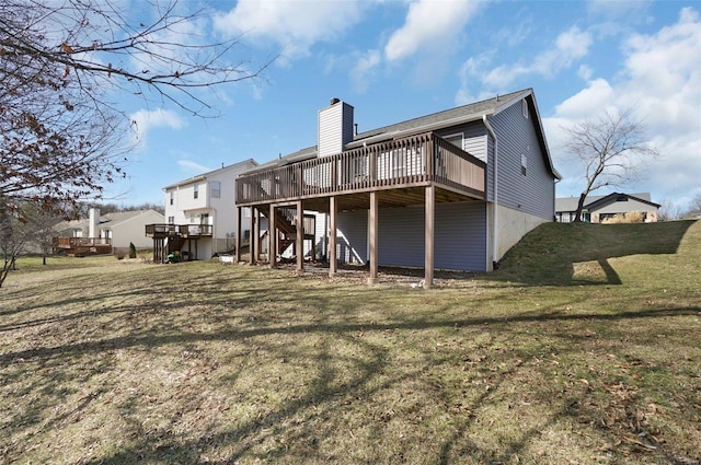 rear view of house featuring stairway, a lawn, a chimney, and a deck