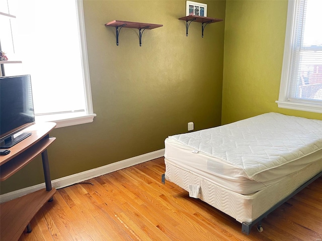 bedroom with light wood-style flooring and baseboards