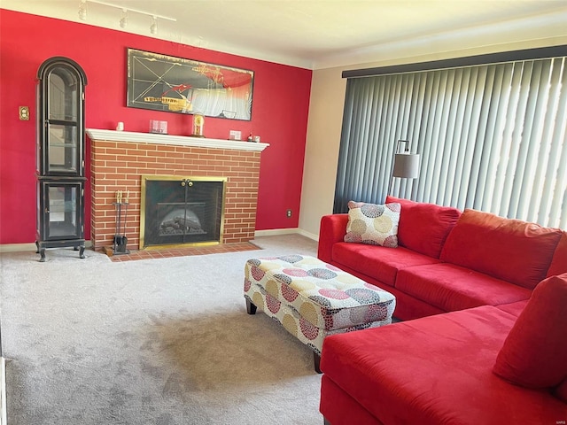 carpeted living room featuring a fireplace, baseboards, and track lighting