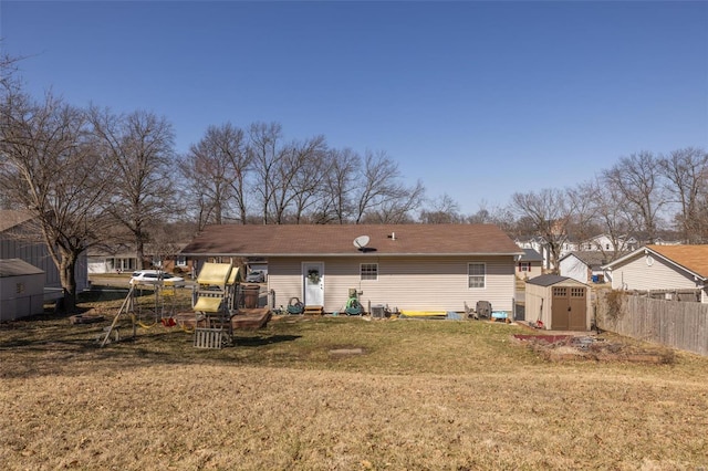 back of house featuring a yard, a shed, fence, and an outdoor structure