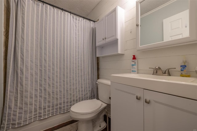 full bath with a textured ceiling, shower / tub combo, vanity, and toilet