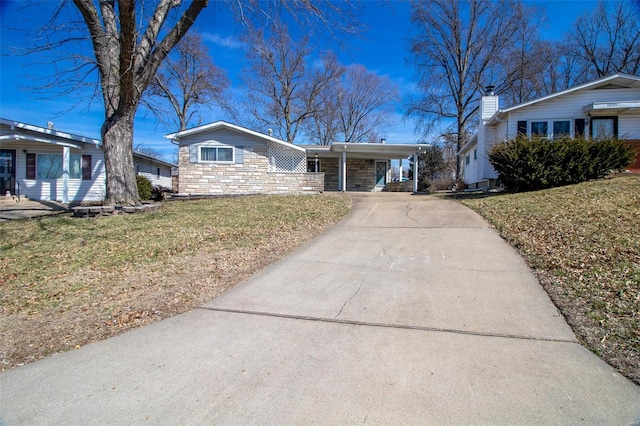 ranch-style house featuring a carport, stone siding, driveway, and a front lawn