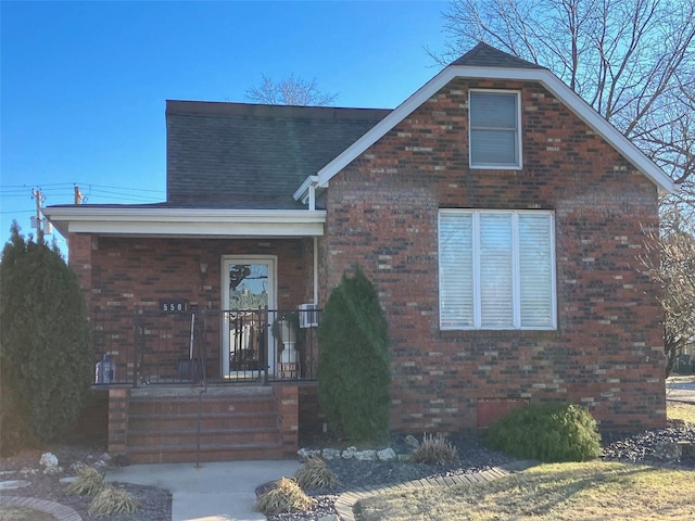 view of front of house with brick siding, crawl space, and a porch