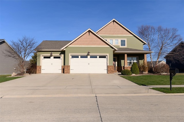 craftsman-style house with brick siding, a garage, a front yard, and driveway