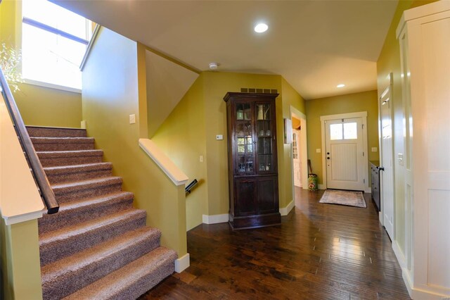 foyer featuring dark wood-type flooring, recessed lighting, stairway, a skylight, and baseboards