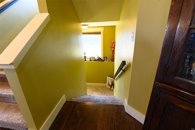 staircase featuring baseboards and wood finished floors