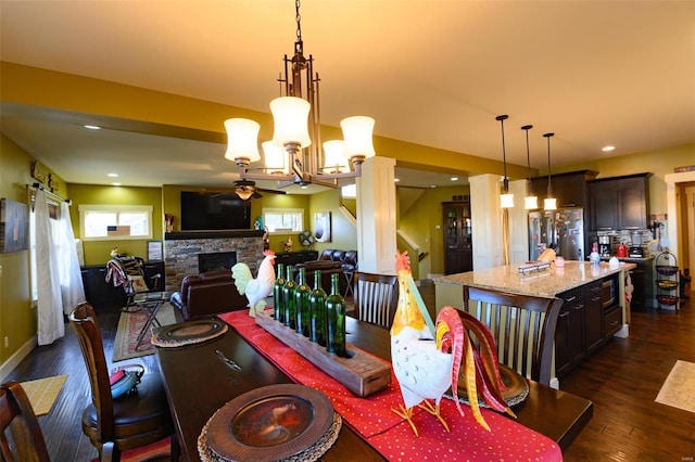 dining space featuring ceiling fan, recessed lighting, a fireplace, ornate columns, and dark wood-style flooring