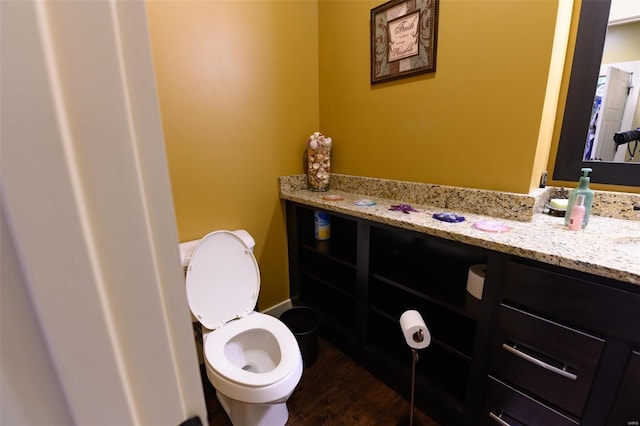 bathroom with toilet, wood finished floors, and vanity