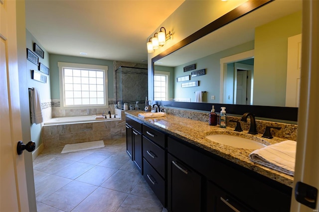 bathroom with tile patterned floors, double vanity, tiled shower, a bath, and a sink