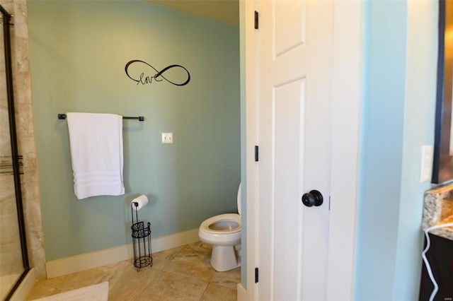 bathroom with tile patterned flooring, a stall shower, toilet, and baseboards