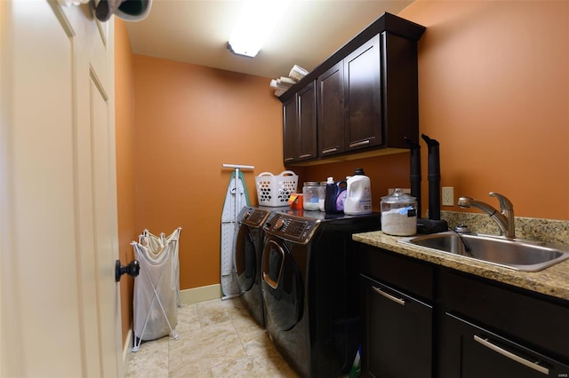 laundry area featuring light tile patterned floors, baseboards, cabinet space, a sink, and washer and dryer