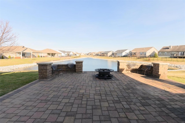 view of patio featuring a residential view, fence, and an outdoor fire pit