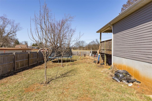 view of yard with a trampoline and a fenced backyard