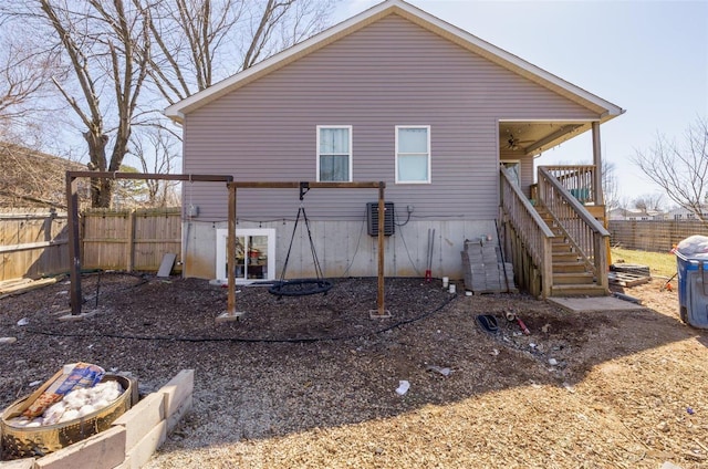 view of property exterior with a ceiling fan, fence, and stairs