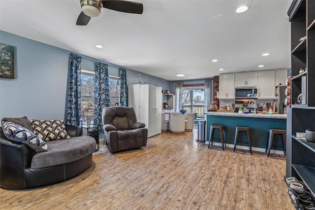 living area with light wood-style floors, recessed lighting, and a ceiling fan