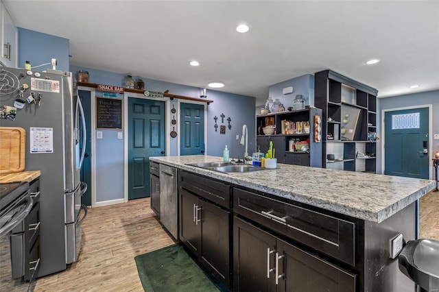 kitchen with light countertops, appliances with stainless steel finishes, light wood-type flooring, and a sink