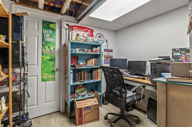 home office with a drop ceiling and wood finished floors