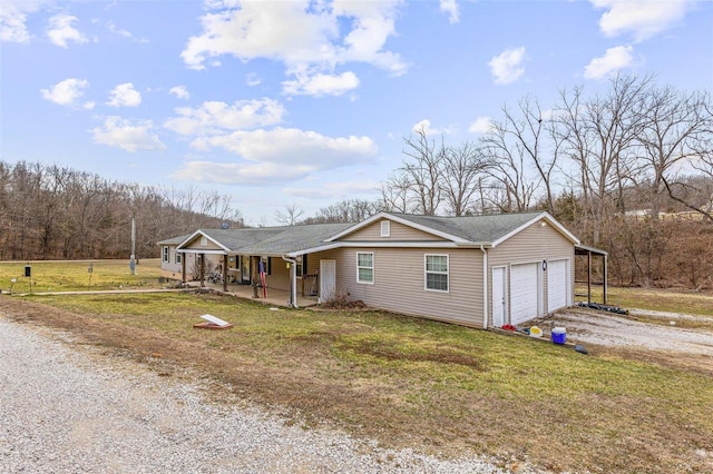 ranch-style home featuring driveway, a garage, a porch, and a front lawn