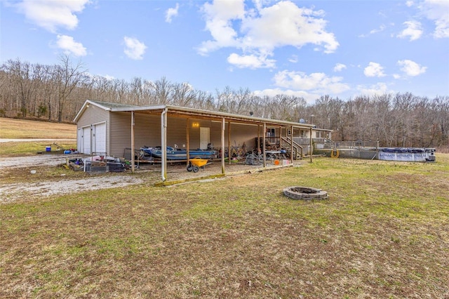 view of pole building featuring a fire pit, a yard, and a covered pool