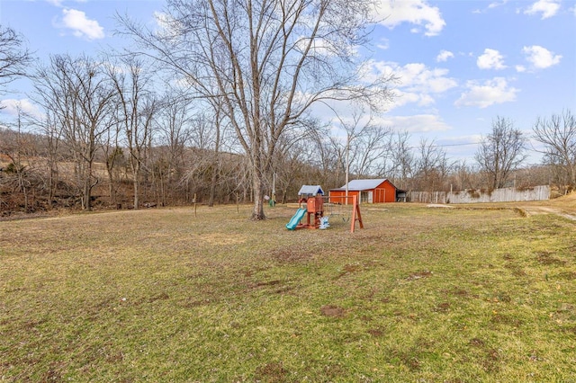 view of yard featuring an outbuilding, a playground, and a storage unit