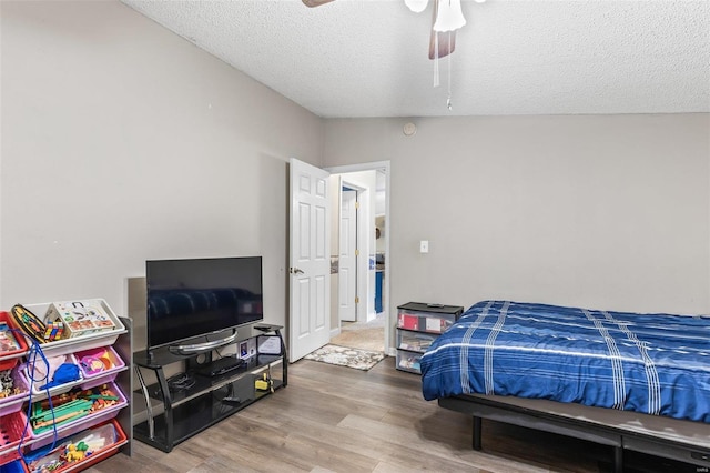 bedroom featuring a ceiling fan, a textured ceiling, and wood finished floors