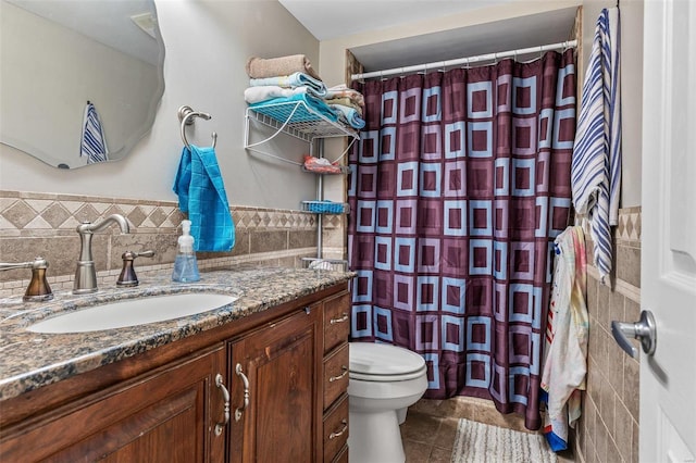 full bathroom featuring a shower with shower curtain, toilet, tile patterned flooring, vanity, and tile walls