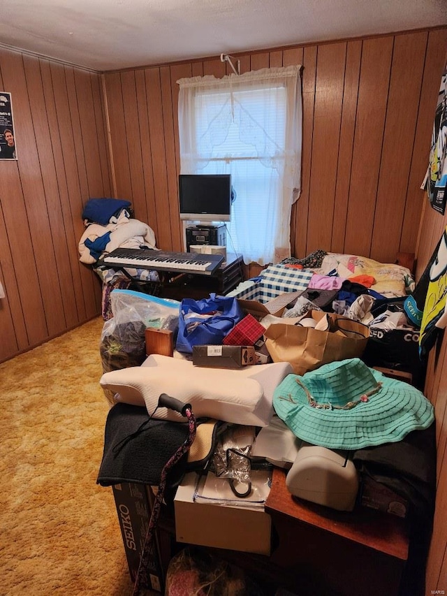 bedroom with carpet floors and wooden walls