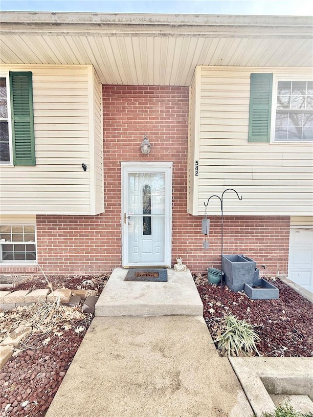 property entrance featuring brick siding