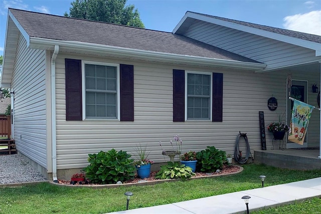 view of front of property featuring a front lawn and a shingled roof