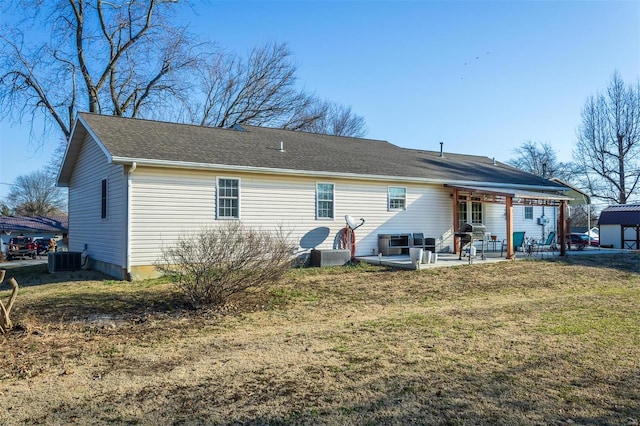 rear view of house featuring cooling unit, a patio area, and a lawn