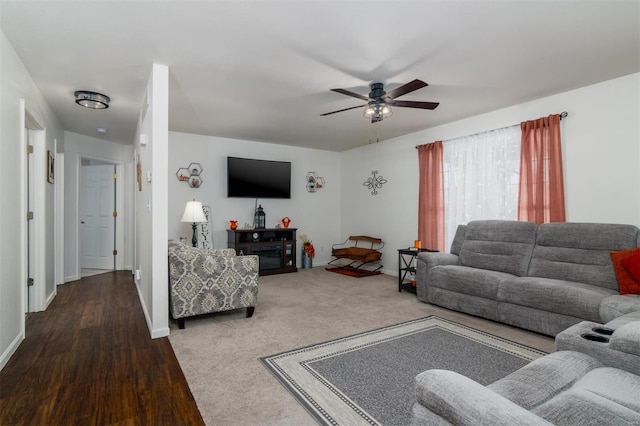 living area with baseboards and a ceiling fan