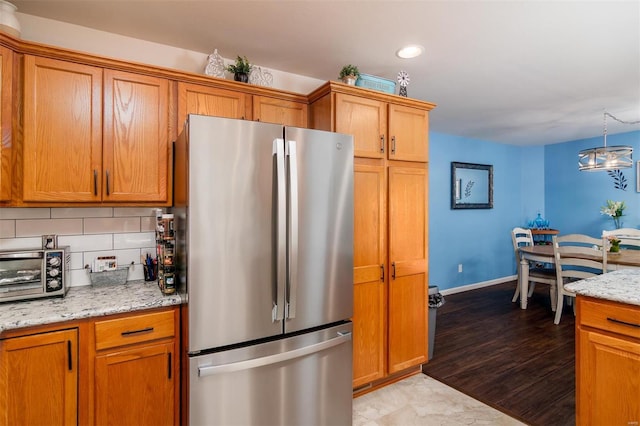 kitchen with brown cabinetry and freestanding refrigerator