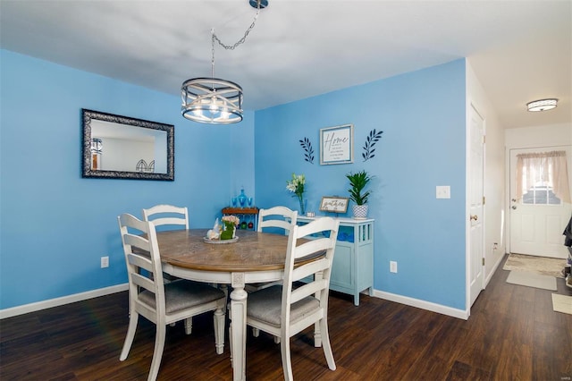 dining room with a chandelier, baseboards, and wood finished floors