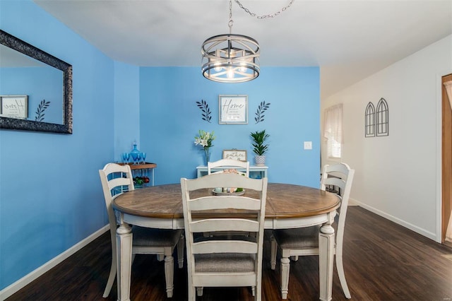 dining space featuring a notable chandelier, baseboards, and wood finished floors