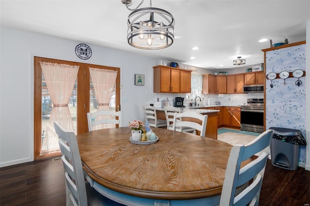 dining space with recessed lighting, wood finished floors, baseboards, and a chandelier