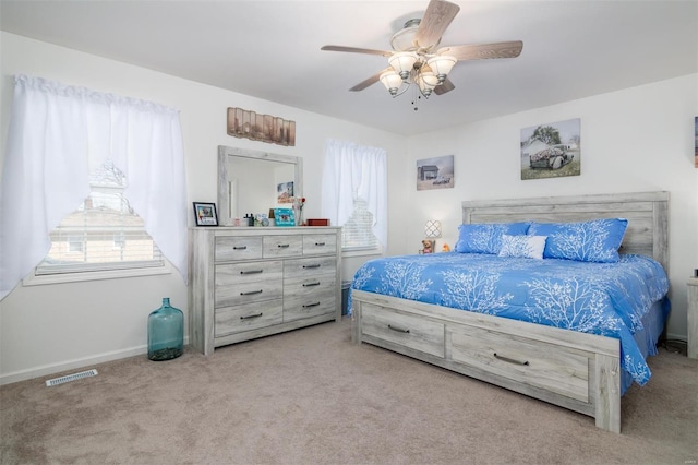 carpeted bedroom with a ceiling fan, visible vents, and baseboards