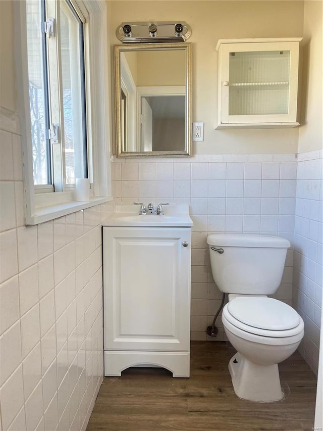 bathroom featuring tile walls, toilet, and wood finished floors