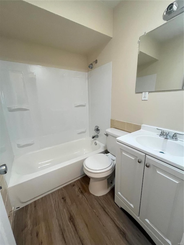 bathroom with shower / bathtub combination, vanity, wood finished floors, and toilet