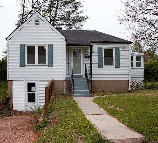 view of front of home featuring a front lawn and a shingled roof